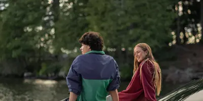 Friends sitting on boat looking  at Muskoka shoreline