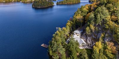 Cottage on perch above dock with long lake views