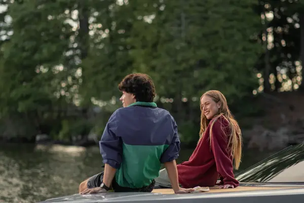 Friends sitting on boat looking  at Muskoka shoreline