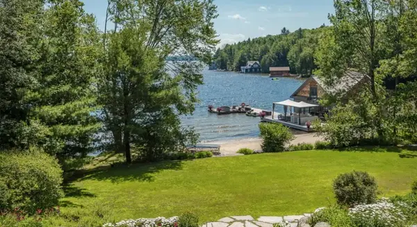 cottage shoreline with boathouse and green grass